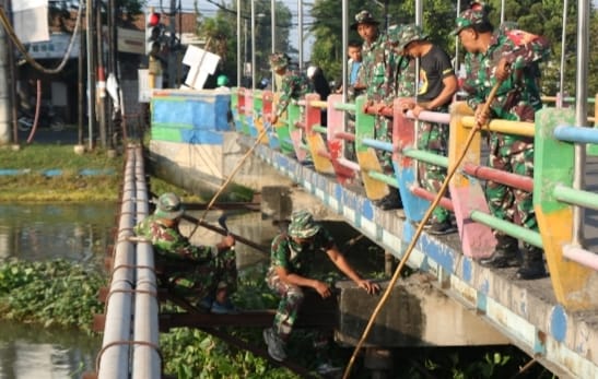 Guyub rukun, Satgas TMMD 120 Kodim 0816/Sidoarjo melaksanakan pembersihan sungai dan jalan raya